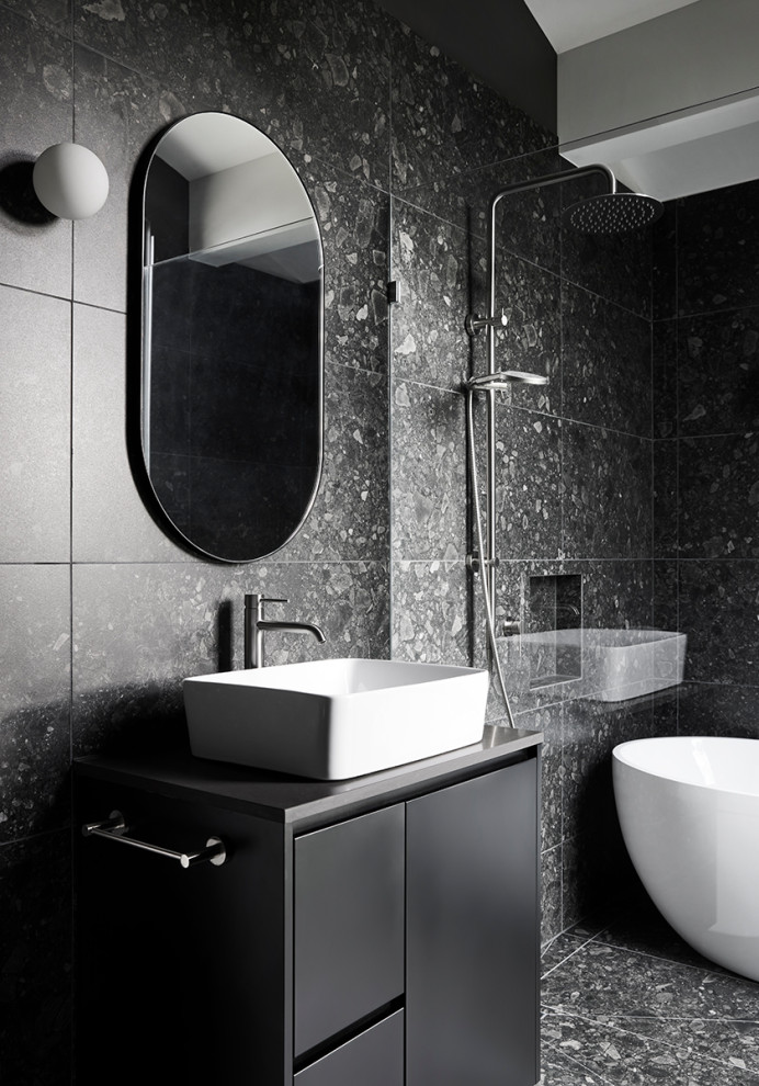 Пример оригинального дизайна: большая ванная комната в современном стиле с черными фасадами, отдельно стоящей ванной, душем над ванной, черной плиткой, мраморной плиткой, черными стенами, мраморным полом, настольной раковиной, черным полом, черной столешницей, тумбой под одну раковину и напольной тумбой