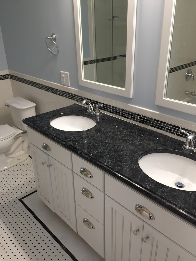 Photo of a mid-sized transitional bathroom in Other with an undermount sink, recessed-panel cabinets, white cabinets, engineered quartz benchtops, white tile, ceramic tile, blue walls and ceramic floors.