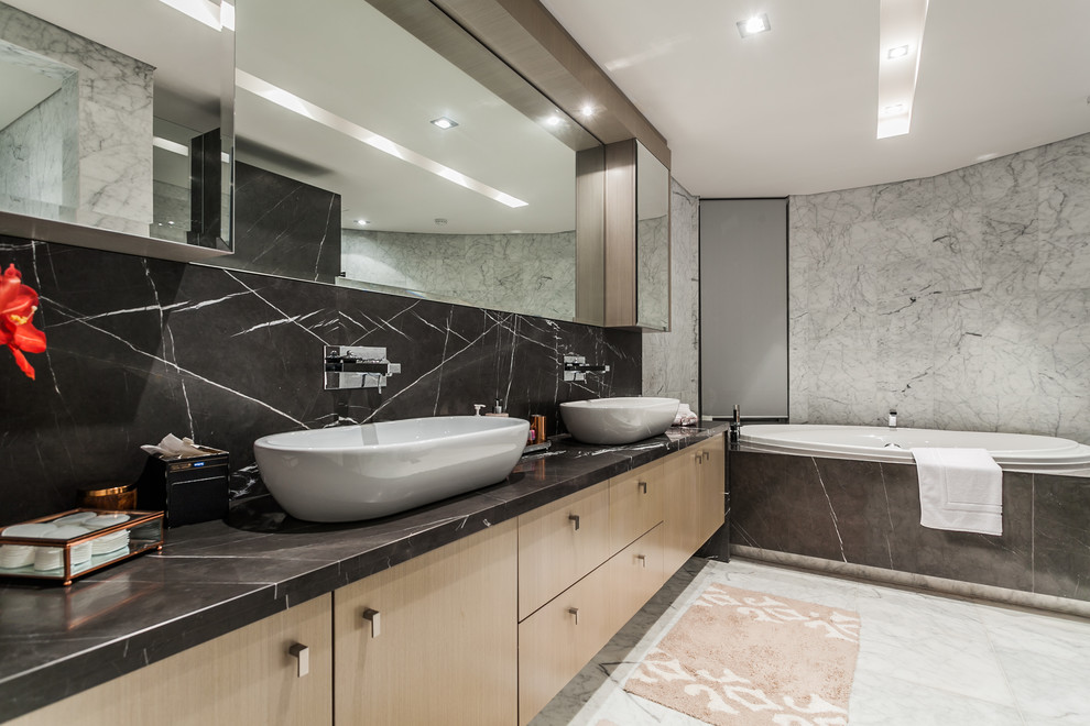 Contemporary master bathroom in Perth with flat-panel cabinets, light wood cabinets, an alcove tub and a vessel sink.