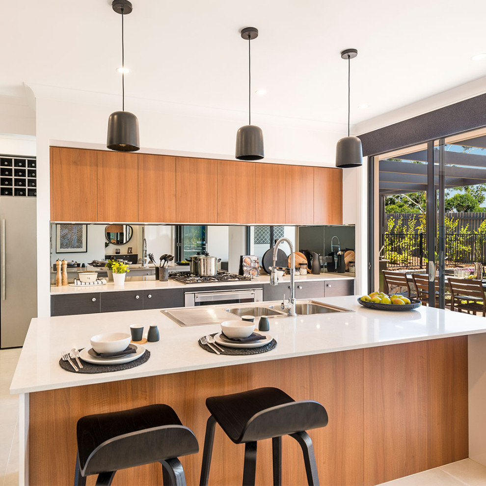This is an example of a large contemporary galley open plan kitchen in Canberra - Queanbeyan with shaker cabinets, dark wood cabinets, quartz benchtops, metallic splashback, mirror splashback, stainless steel appliances, ceramic floors, with island, beige floor and yellow benchtop.