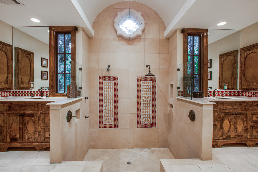Photo of a mediterranean master bathroom in Dallas with an undermount sink, medium wood cabinets, a double shower, multi-coloured tile, beige walls and shaker cabinets.