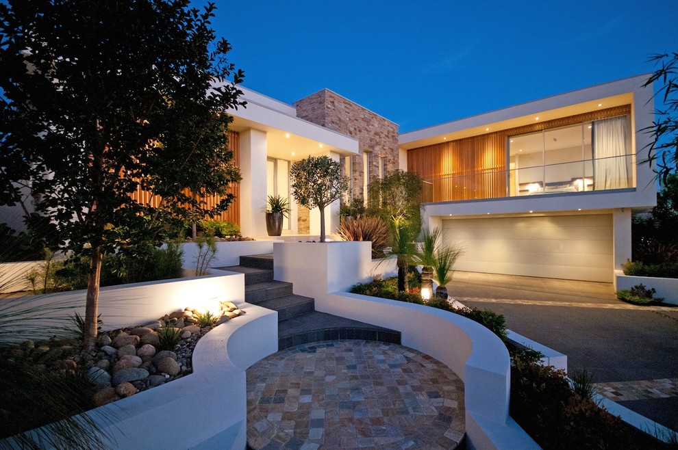 Mid-sized contemporary front yard full sun garden in Sydney with a retaining wall and natural stone pavers.