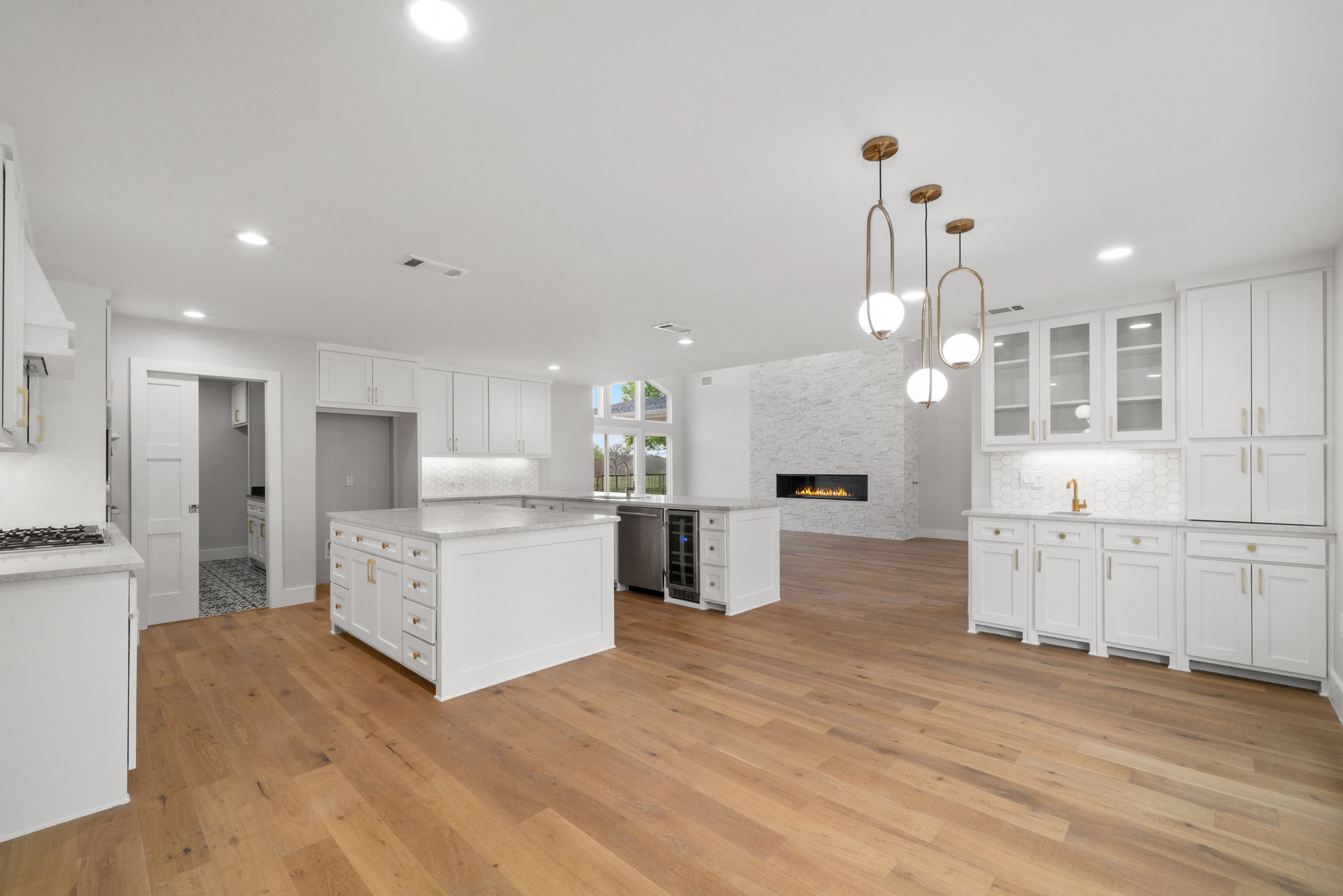 Love a white kitchen! This lovely open concept living/dining/kitchen features white oak engineered hardwood floors, shite shaker style cabinets, a peninsula and island.