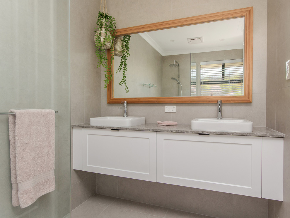 Small traditional kids bathroom in Perth with flat-panel cabinets, white cabinets, a freestanding tub, an open shower, a one-piece toilet, gray tile, ceramic tile, grey walls, ceramic floors, a vessel sink, granite benchtops, grey floor, an open shower and grey benchtops.