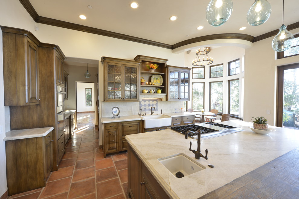 Design ideas for a large traditional l-shaped separate kitchen in San Francisco with a farmhouse sink, raised-panel cabinets, dark wood cabinets, quartzite benchtops, beige splashback, ceramic splashback, stainless steel appliances, terra-cotta floors, with island, red floor and beige benchtop.