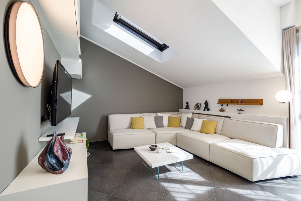 Ispirazione per un soggiorno minimalista di medie dimensioni e stile loft con pareti grigie, pavimento in gres porcellanato, TV a parete, pavimento grigio e soffitto ribassato