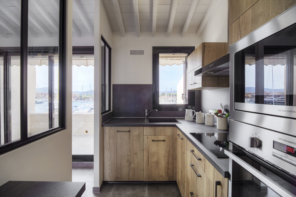Inspiration for a small contemporary l-shaped separate kitchen in Marseille with a single-bowl sink, beaded inset cabinets, light wood cabinets, marble benchtops, black splashback, marble splashback, stainless steel appliances, ceramic floors, no island, grey floor, black benchtop and wood.