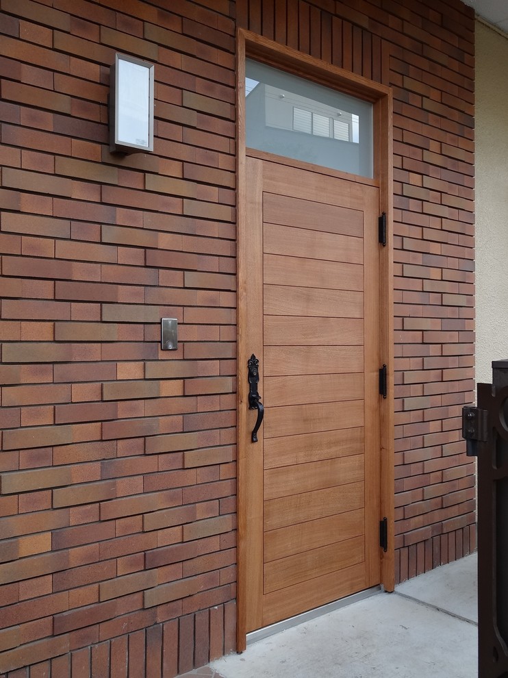 Large scandinavian front door in Tokyo with white walls, brick floors, a single front door, a medium wood front door and brown floor.
