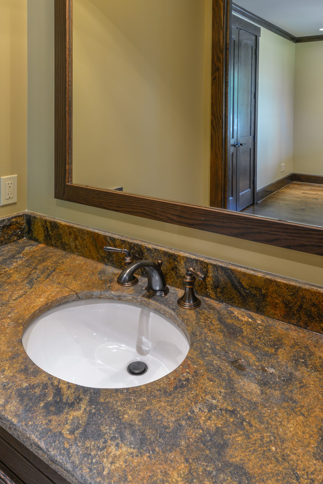 Inspiration for a mid-sized rustic 3/4 beige tile and ceramic tile alcove bathtub remodel with dark wood cabinets, beige walls, granite countertops, a hinged shower door and brown countertops