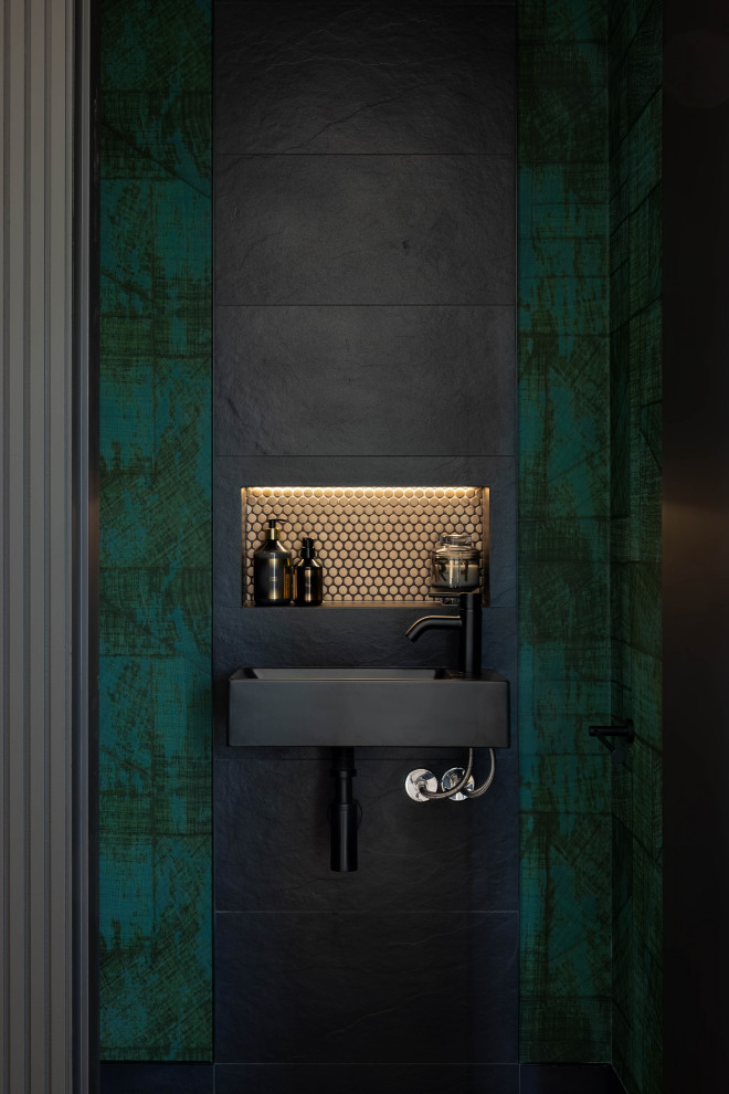 Esempio di un piccolo bagno di servizio moderno con WC monopezzo, pareti verdi, pavimento in gres porcellanato, lavabo sospeso, pavimento nero e carta da parati