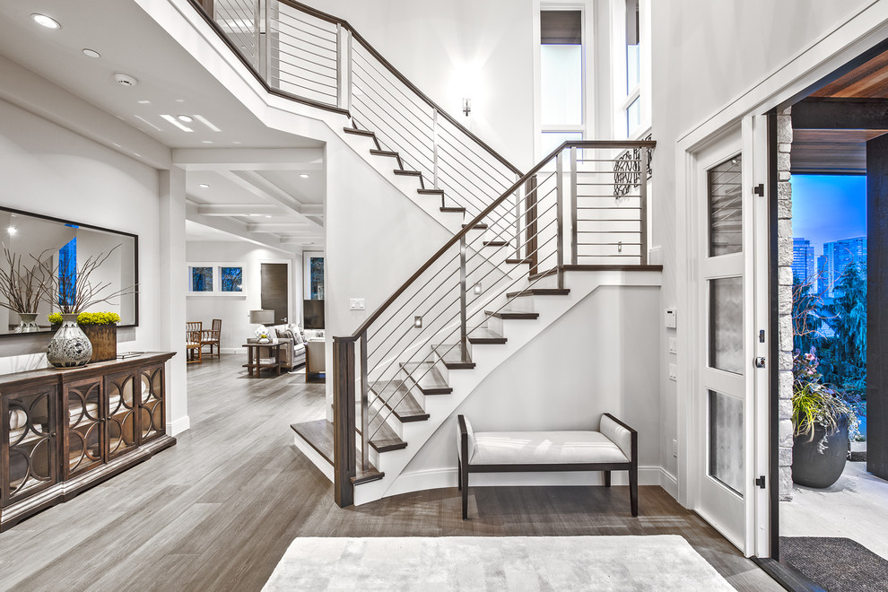 This is an example of a transitional foyer in Seattle with grey walls, medium hardwood floors, a white front door, brown floor and a pivot front door.