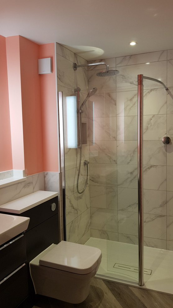 Example of a mid-sized trendy kids' gray tile and ceramic tile vinyl floor, gray floor and single-sink bathroom design in Kent with flat-panel cabinets, dark wood cabinets, a wall-mount toilet, pink walls, an integrated sink, solid surface countertops, white countertops and a floating vanity