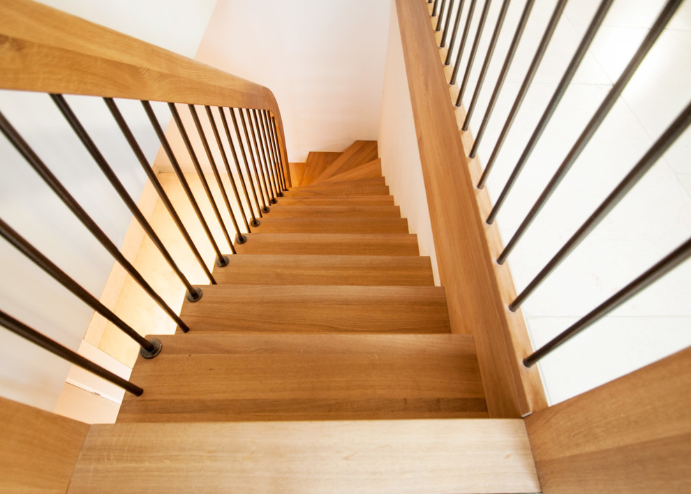 Design ideas for a mid-sized modern wood curved staircase in Buckinghamshire with wood risers and mixed railing.
