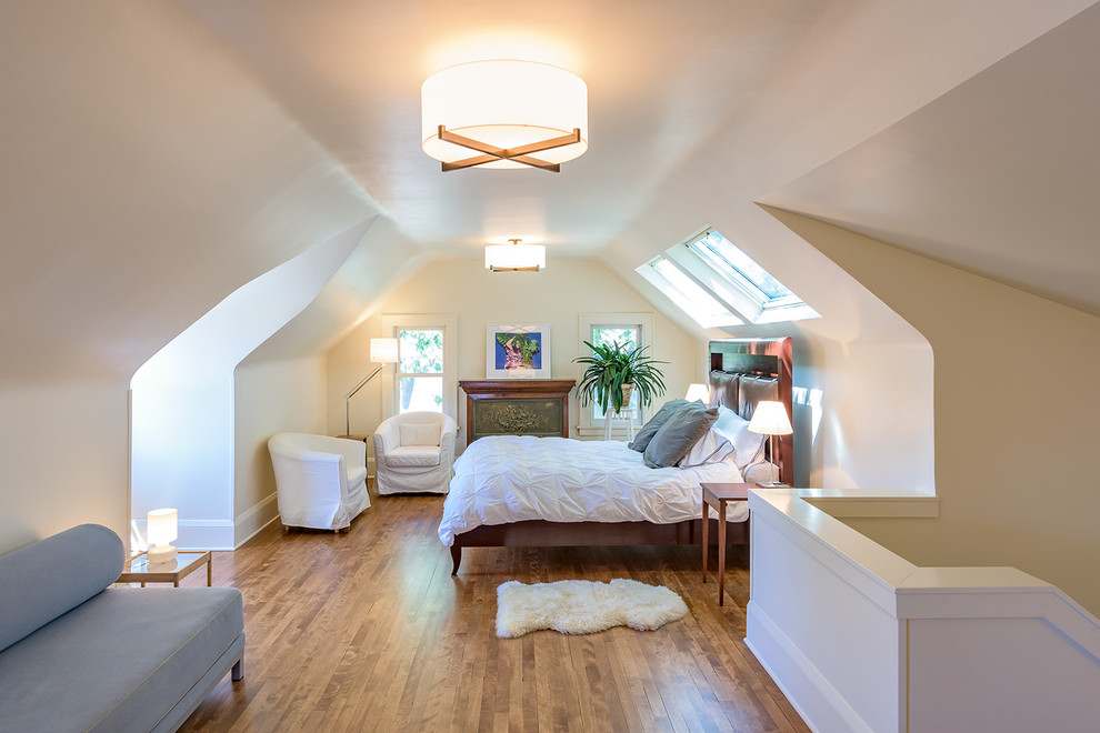 This is an example of a small traditional loft-style bedroom in Minneapolis with white walls, medium hardwood floors, a standard fireplace and a metal fireplace surround.
