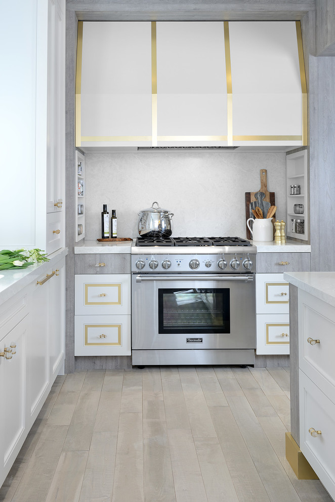 Open concept kitchen - mid-sized transitional u-shaped light wood floor and gray floor open concept kitchen idea in Toronto with an undermount sink, shaker cabinets, white cabinets, solid surface countertops, stainless steel appliances and an island