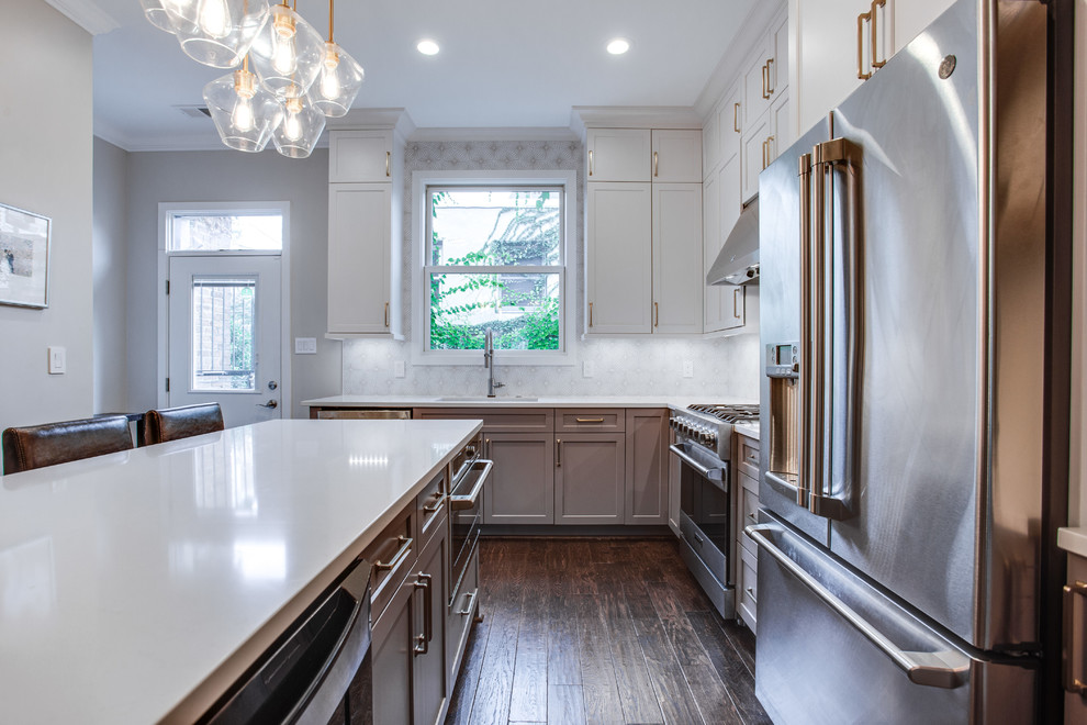 Eat-in kitchen - large transitional l-shaped medium tone wood floor and brown floor eat-in kitchen idea in DC Metro with an undermount sink, shaker cabinets, white cabinets, solid surface countertops, white backsplash, ceramic backsplash, stainless steel appliances, an island and white countertops
