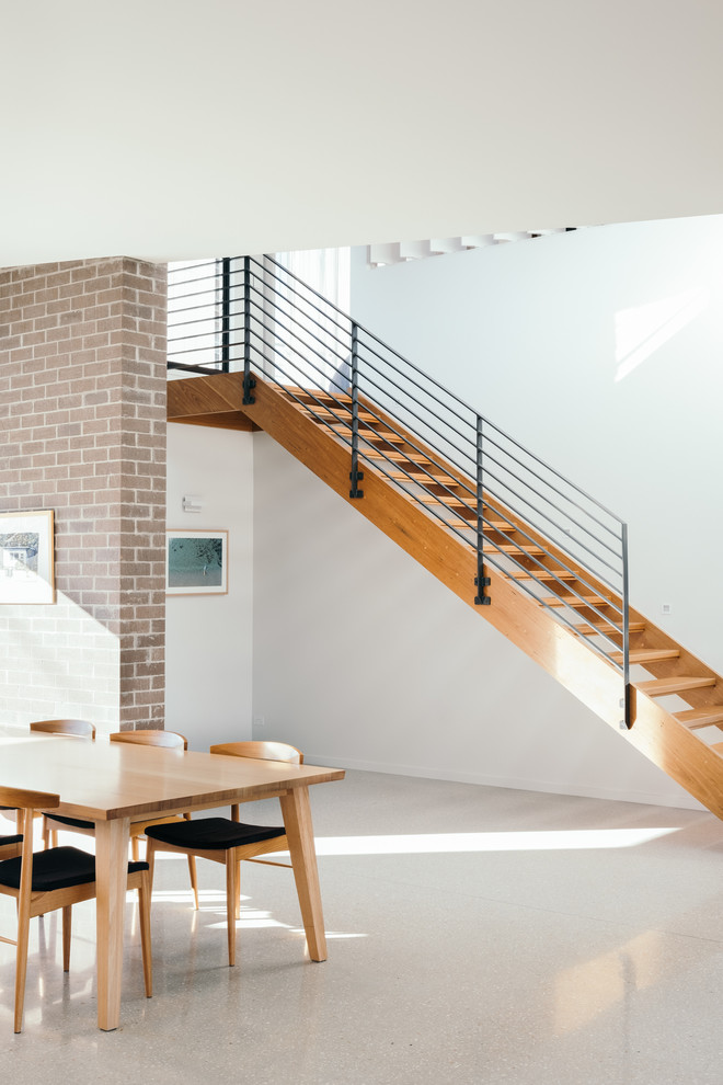 Photo of a mid-sized contemporary wood straight staircase in Gold Coast - Tweed with open risers and metal railing.