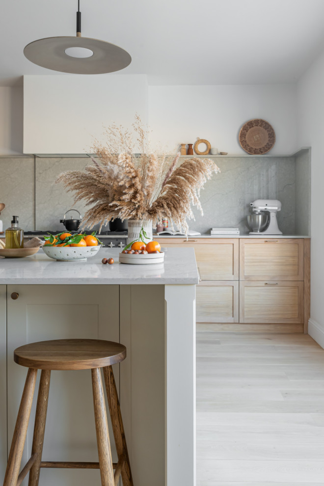 Foto di una grande cucina nordica con lavello integrato, ante in stile shaker, ante in legno chiaro, top in quarzite, paraspruzzi grigio, elettrodomestici neri, parquet chiaro e top grigio
