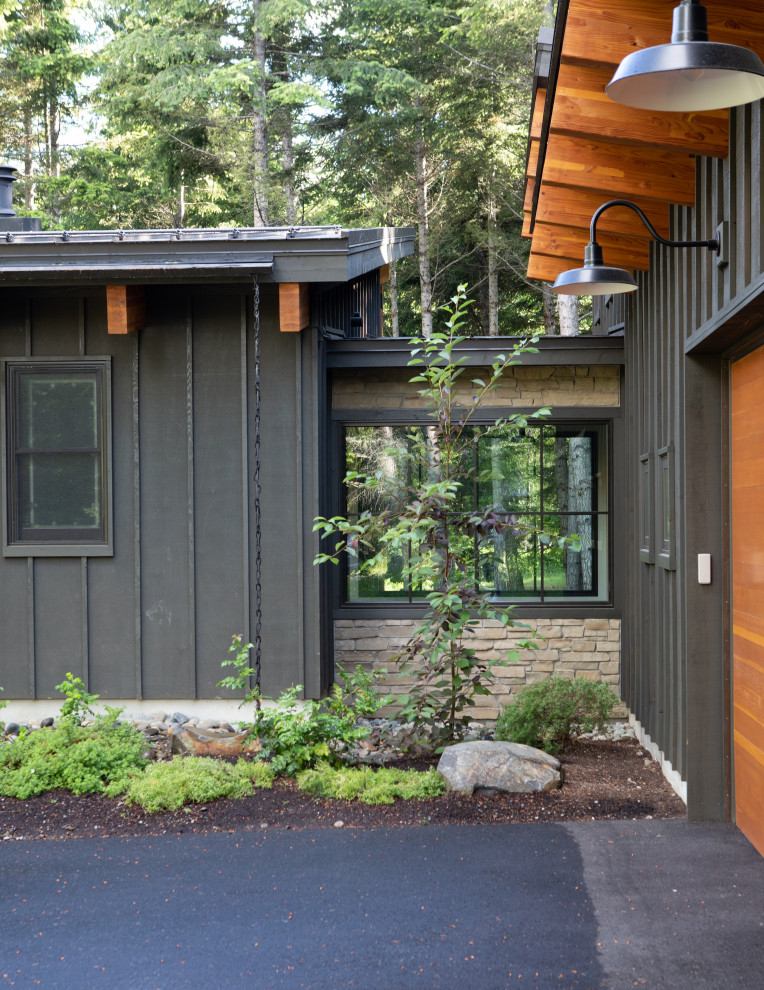Photo of a mid-sized modern two-storey grey house exterior in Seattle with wood siding, a shed roof, a metal roof, a grey roof and board and batten siding.