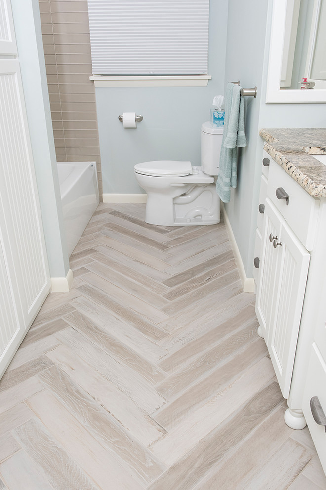 Example of a mid-sized transitional 3/4 brown tile and glass tile porcelain tile and beige floor corner shower design with recessed-panel cabinets, white cabinets, a one-piece toilet, gray walls, an undermount sink and granite countertops
