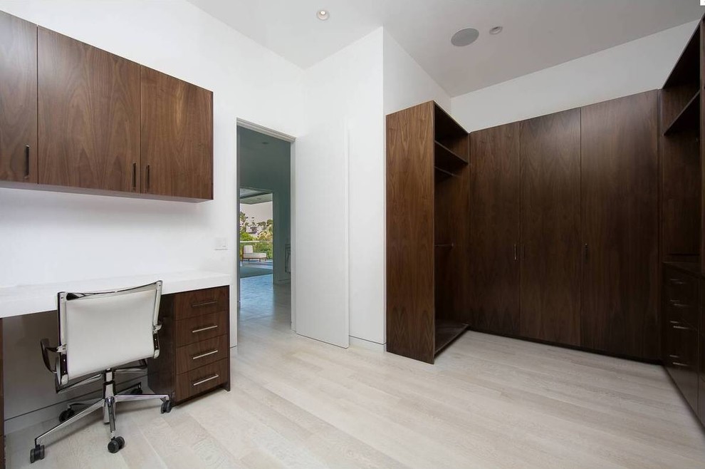 Closet - large contemporary gender-neutral light wood floor closet idea in Los Angeles with flat-panel cabinets and dark wood cabinets