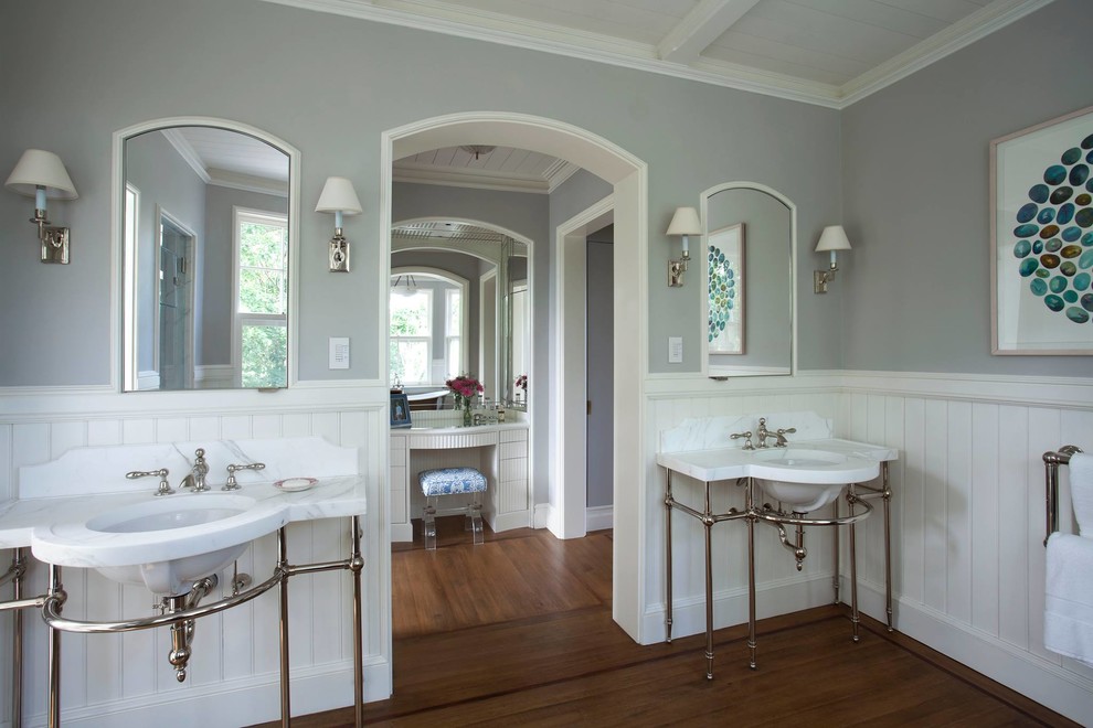 Inspiration for a large beach style master bathroom in New York with grey walls, an undermount sink, open cabinets, a two-piece toilet, medium hardwood floors, marble benchtops, brown floor and white benchtops.