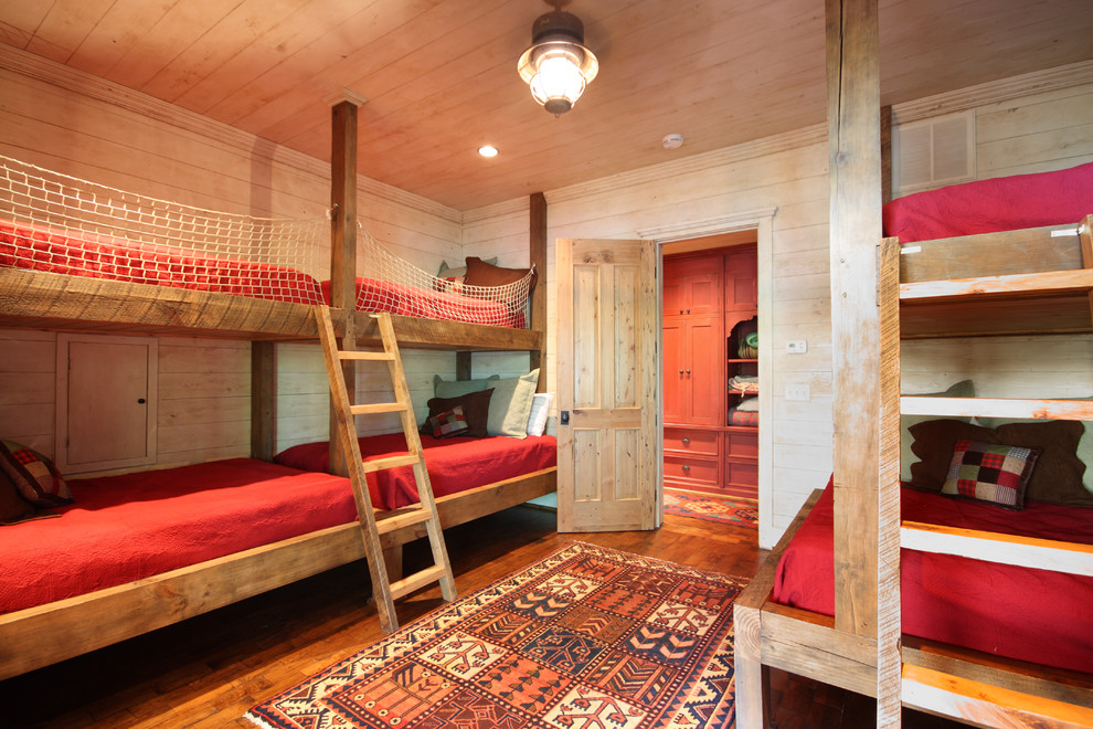 This is an example of a mid-sized country gender-neutral kids' bedroom for kids 4-10 years old in Atlanta with medium hardwood floors, beige walls and brown floor.