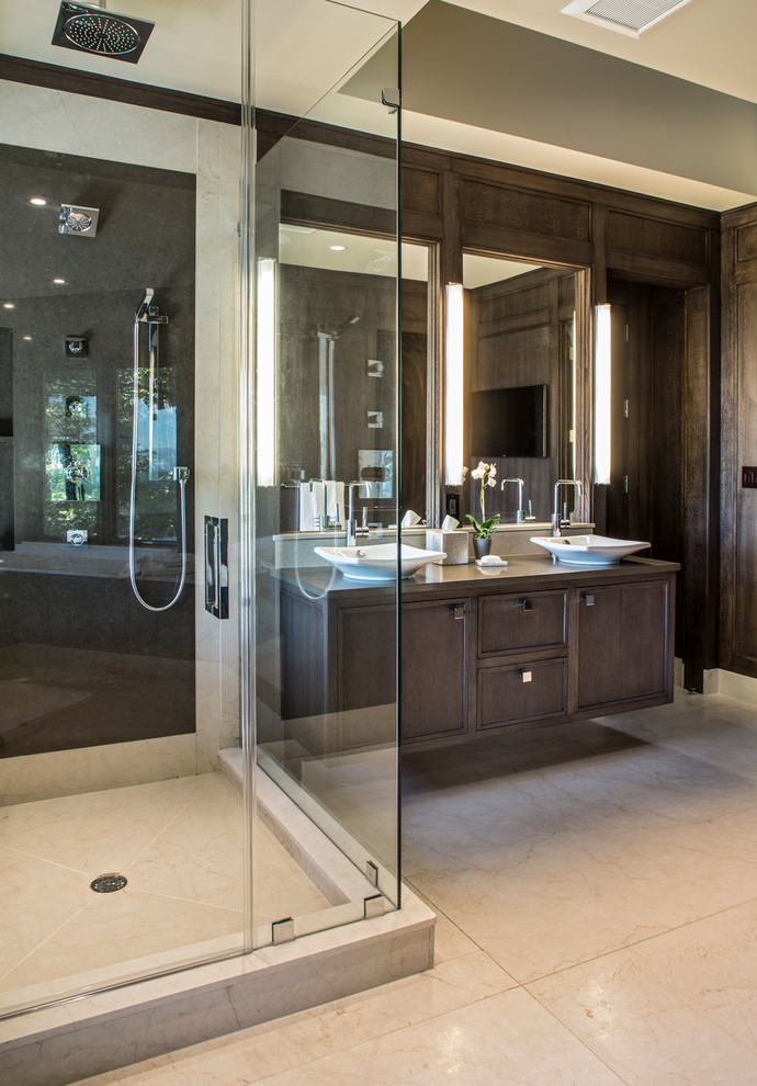 Photo of a large contemporary master bathroom in Other with recessed-panel cabinets, dark wood cabinets, an undermount tub, a corner shower, a two-piece toilet, beige tile, stone slab, beige walls, marble floors, a vessel sink and engineered quartz benchtops.