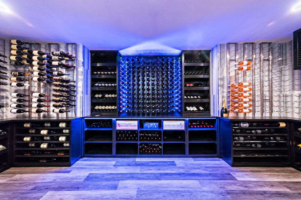 Photo of a large modern wine cellar in New York with porcelain floors, display racks and grey floor.