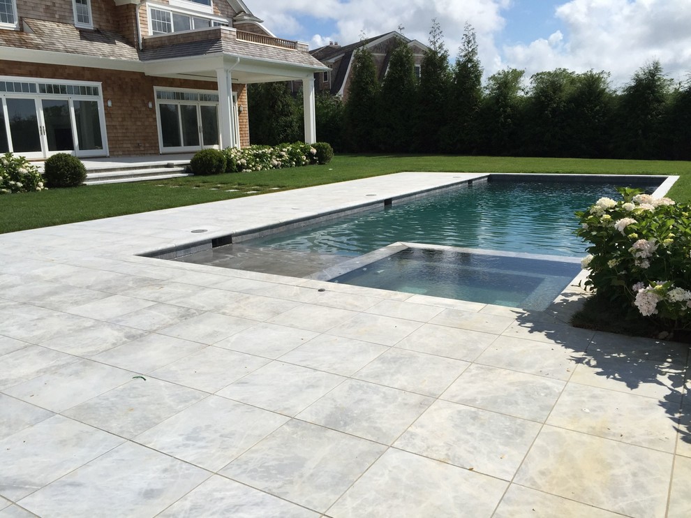 Example of a large backyard stone and rectangular lap hot tub design in New York