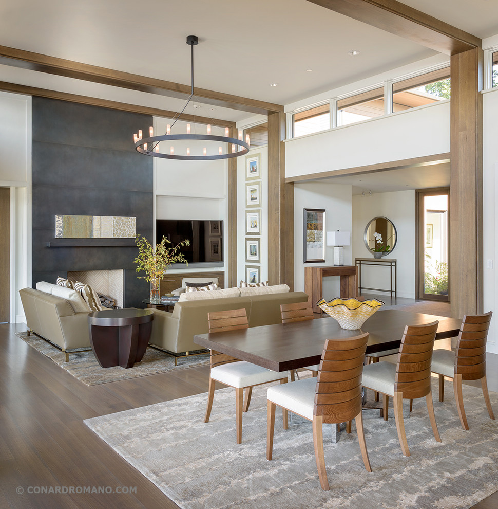 This is an example of a large contemporary open concept living room in Seattle with white walls, dark hardwood floors, a standard fireplace, a metal fireplace surround and a wall-mounted tv.