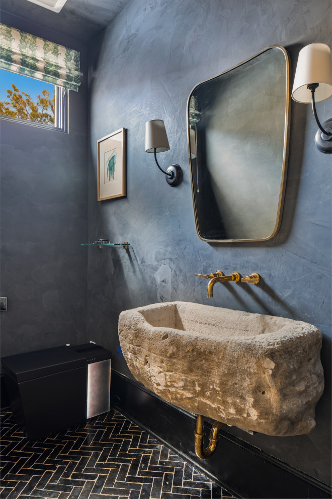 Idées déco pour un WC et toilettes méditerranéen de taille moyenne avec WC à poser, un mur noir, tomettes au sol, un lavabo intégré, un plan de toilette en calcaire, un sol noir, un plan de toilette gris et meuble-lavabo suspendu.