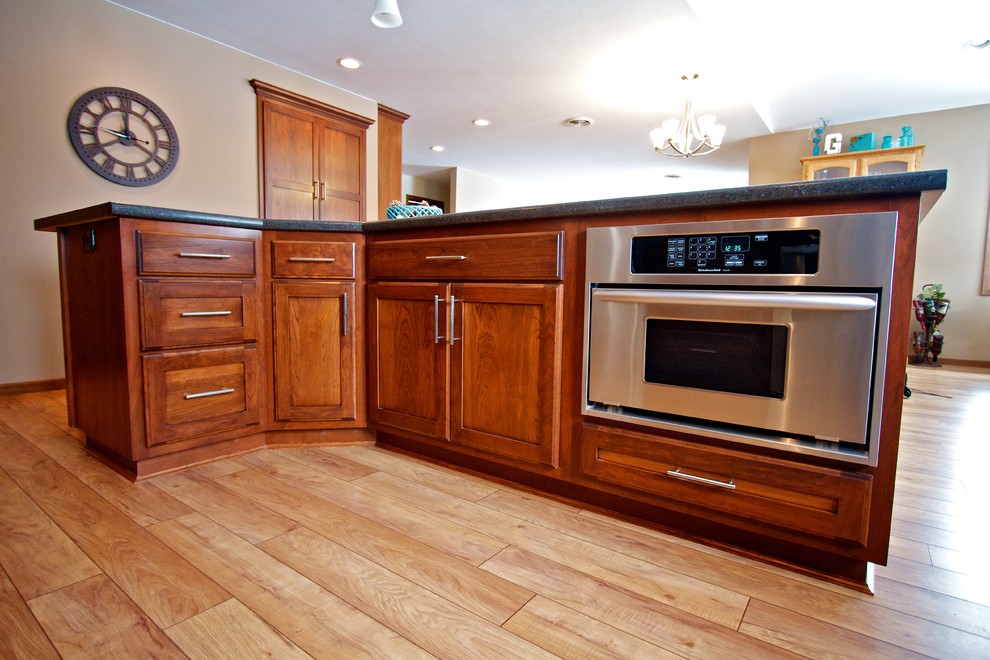 Large open concept kitchen photo with shaker cabinets, dark wood cabinets, laminate countertops and an island