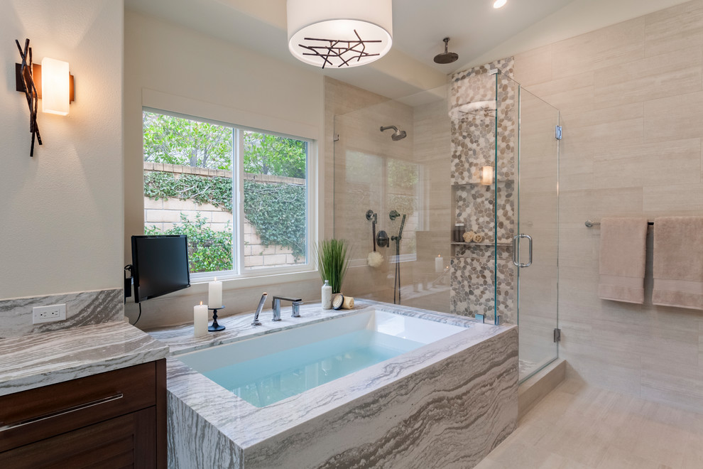 Mid-sized transitional master bathroom in Los Angeles with louvered cabinets, dark wood cabinets, an undermount tub, a corner shower, pebble tile, beige walls, porcelain floors, a vessel sink, engineered quartz benchtops, beige floor, a hinged shower door and multi-coloured benchtops.