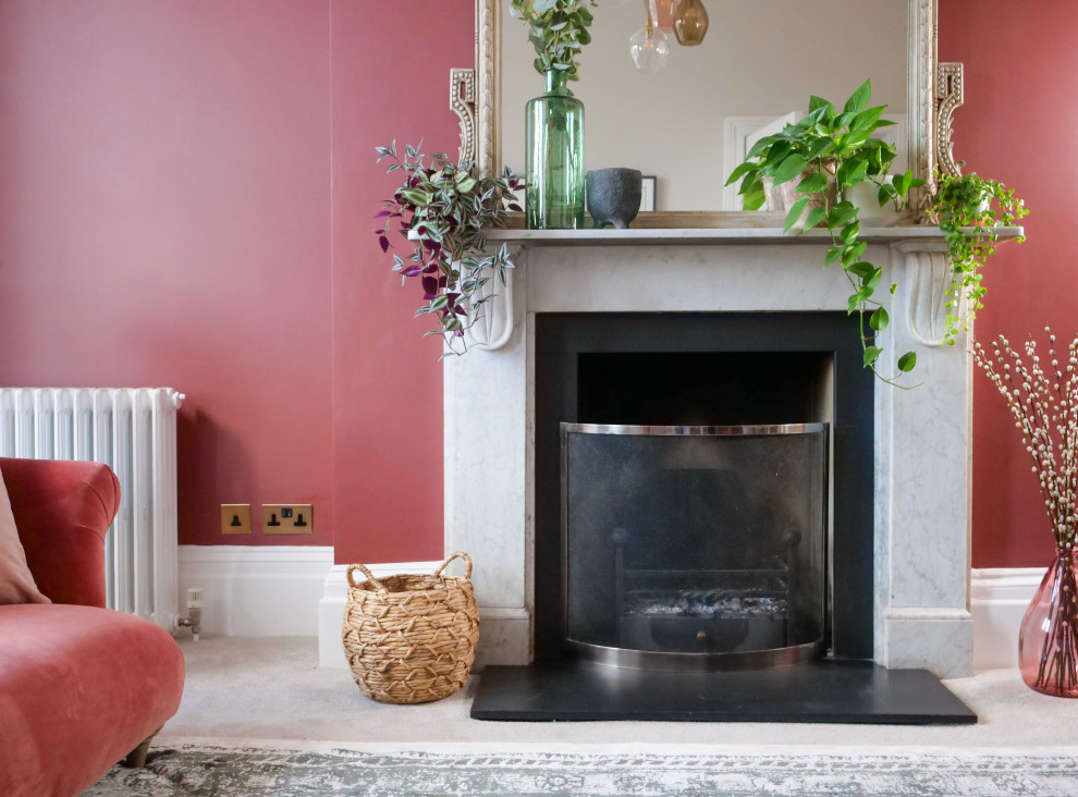 Cette image montre un salon gris et rose traditionnel de taille moyenne et fermé avec un mur rose, moquette, une cheminée standard, un téléviseur fixé au mur, un sol gris et éclairage.