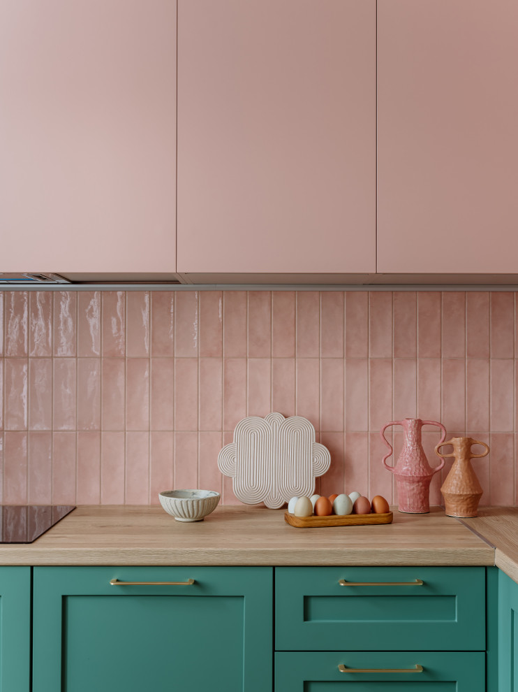 Inredning av ett retro mellanstort kök, med en nedsänkt diskho, gröna skåp, rosa stänkskydd, stänkskydd i keramik och svarta vitvaror