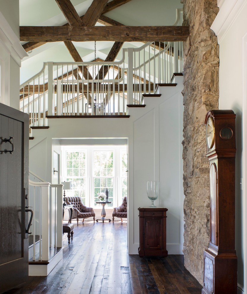 Country foyer in DC Metro with white walls, dark hardwood floors and a dark wood front door.