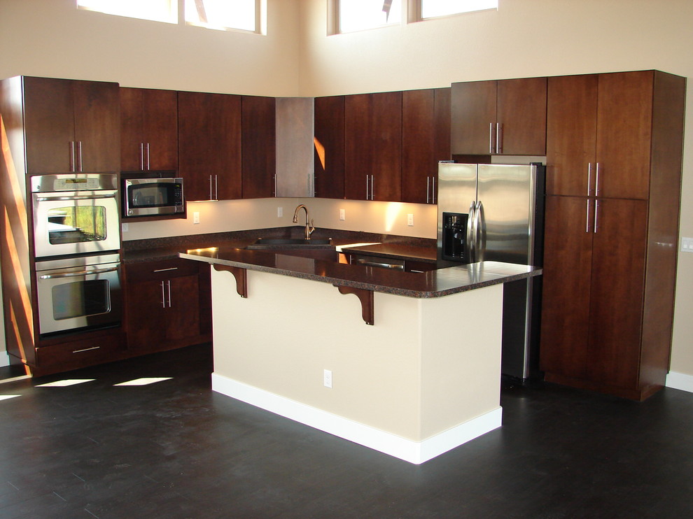 Contemporary l-shaped eat-in kitchen in Denver with flat-panel cabinets, dark wood cabinets and stainless steel appliances.