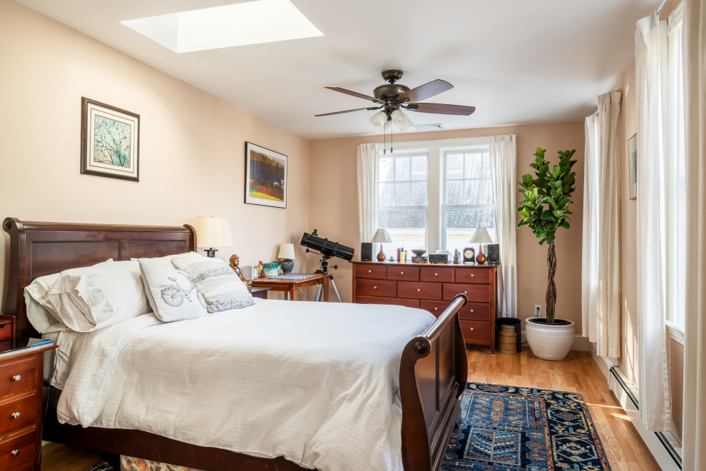 Mid-sized arts and crafts master bedroom in Boston with white walls and light hardwood floors.