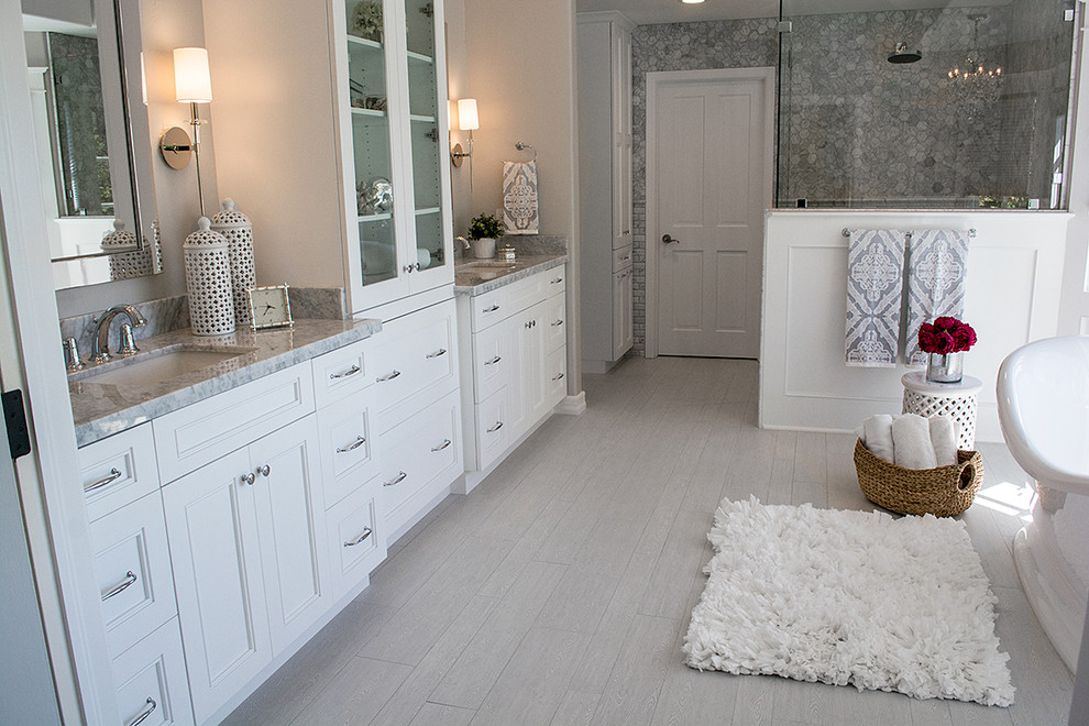 Large transitional master gray tile and stone tile porcelain tile home design photo in Orange County with recessed-panel cabinets, white cabinets, a two-piece toilet, gray walls, an undermount sink and marble countertops