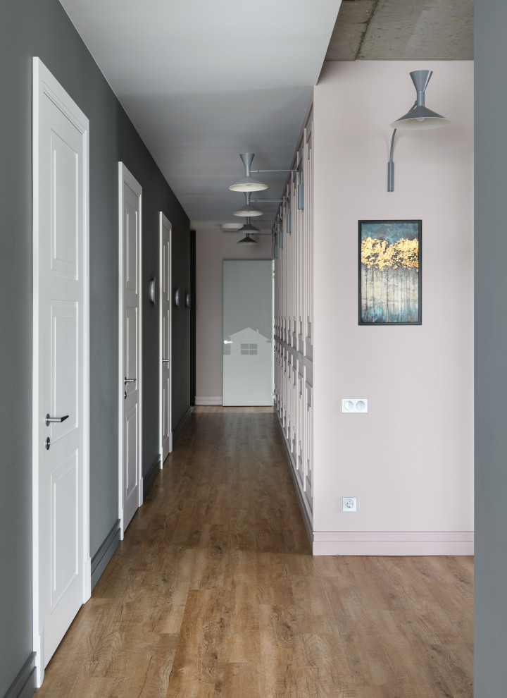 Idée de décoration pour un grand couloir design avec un mur rose, un sol en vinyl et un sol beige.