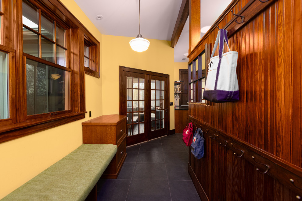 Источник вдохновения для домашнего уюта: тамбур среднего размера в классическом стиле с желтыми стенами, черным полом, сводчатым потолком, полом из керамогранита и панелями на части стены