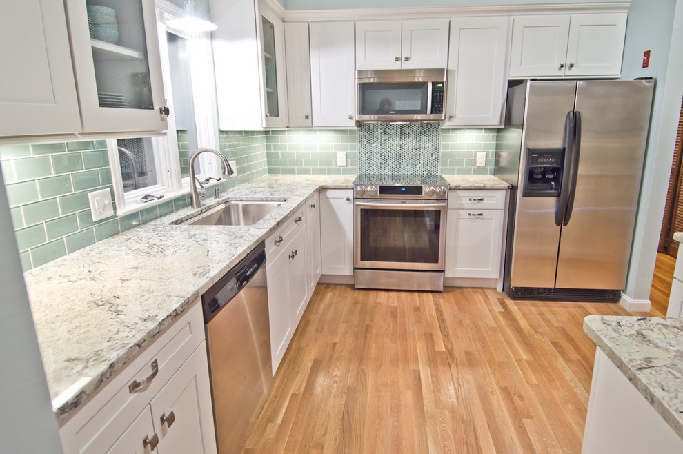 Eat-in kitchen - small transitional l-shaped light wood floor and beige floor eat-in kitchen idea in Boston with an undermount sink, shaker cabinets, white cabinets, green backsplash, subway tile backsplash, stainless steel appliances, an island and gray countertops