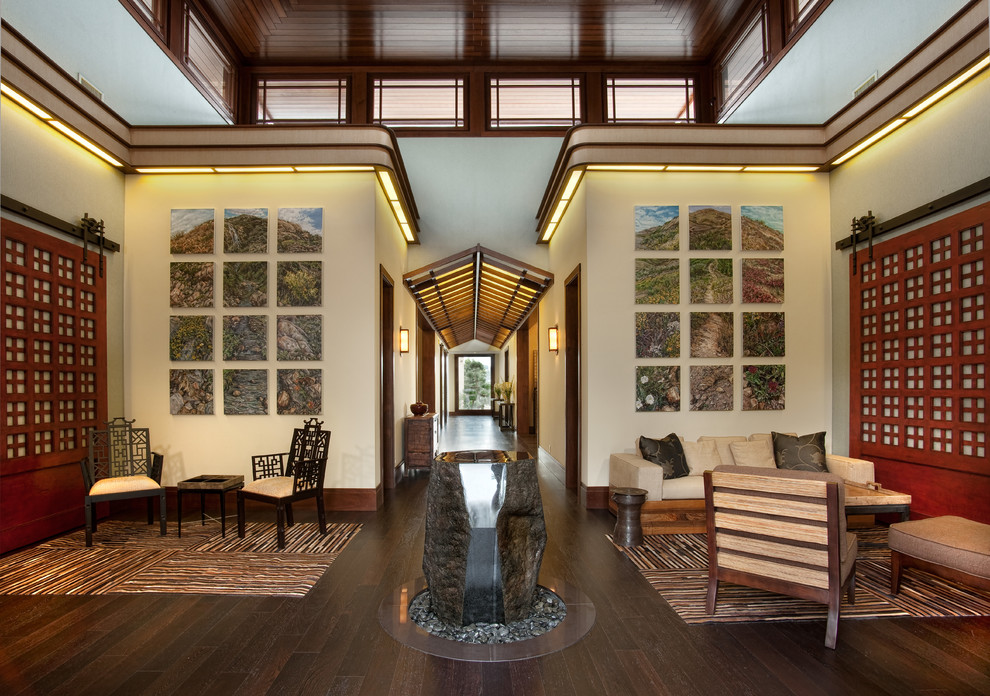 This is an example of a large asian foyer in San Diego with beige walls, dark hardwood floors, a single front door, a medium wood front door and brown floor.