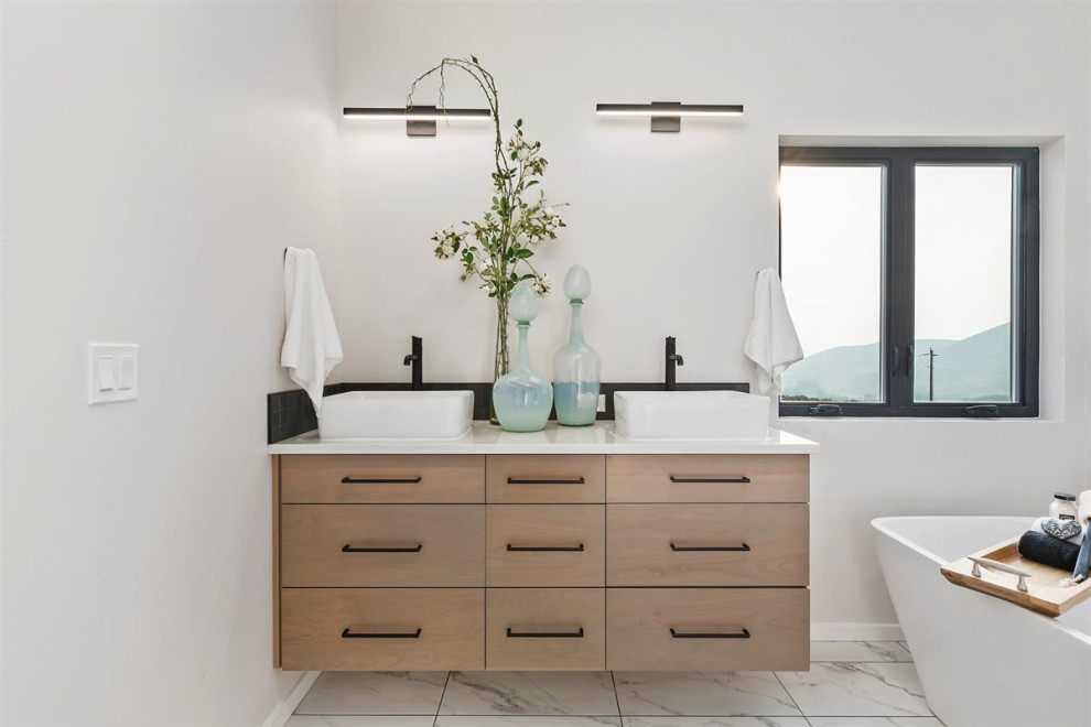 Mid-sized modern master bathroom in Boise with flat-panel cabinets, light wood cabinets, quartzite benchtops, white benchtops, a double vanity, a floating vanity, a freestanding tub, white walls, porcelain floors and white floor.