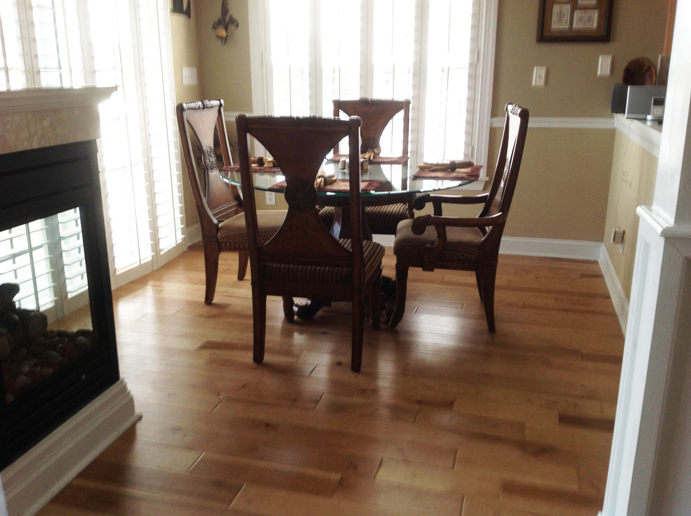 Mid-sized traditional separate dining room in Other with beige walls, medium hardwood floors, a standard fireplace and brown floor.