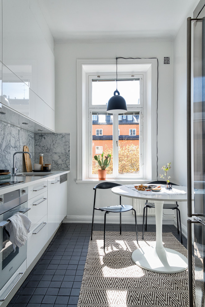 Medium sized scandinavian single-wall kitchen in Stockholm with a submerged sink, flat-panel cabinets, white cabinets, white splashback, stainless steel appliances and no island.