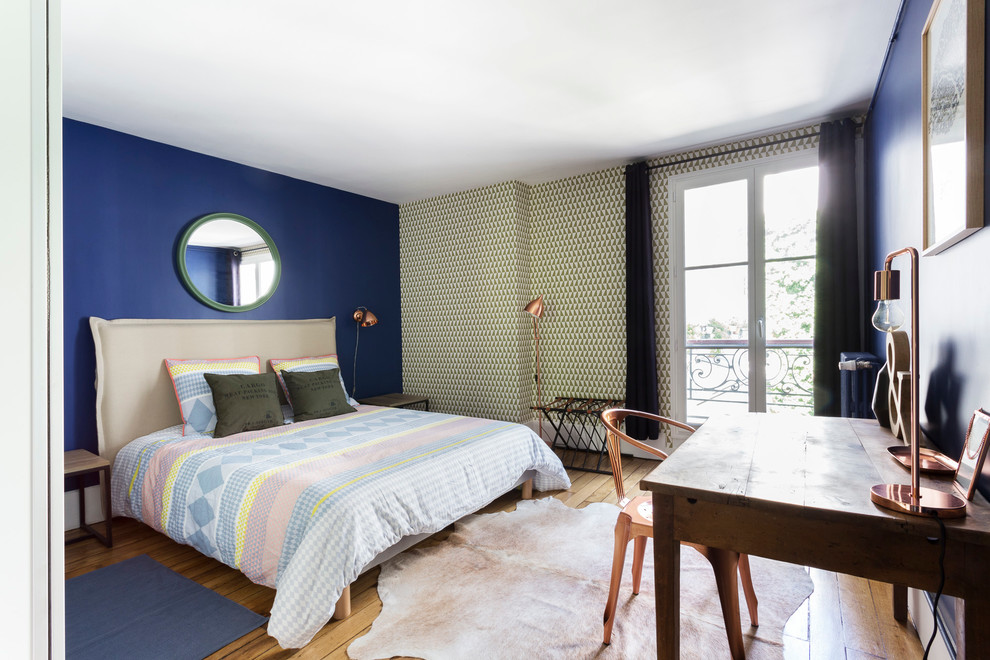 Large contemporary master bedroom in Paris with blue walls and medium hardwood floors.