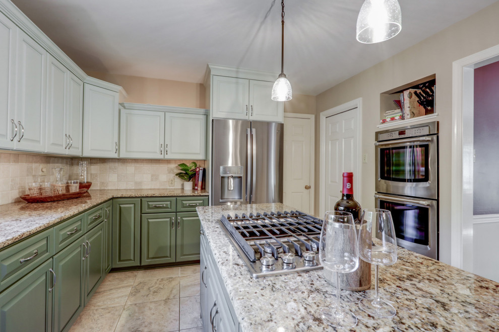 Eat-in kitchen - mid-sized transitional l-shaped ceramic tile and beige floor eat-in kitchen idea with a double-bowl sink, raised-panel cabinets, green cabinets, granite countertops, beige backsplash, ceramic backsplash, stainless steel appliances, an island and beige countertops
