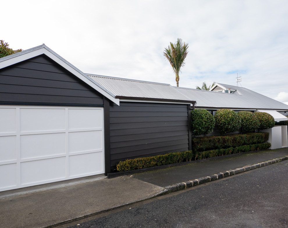 Design ideas for a large contemporary split-level black house exterior in Auckland with wood siding, a gable roof, a metal roof and a grey roof.